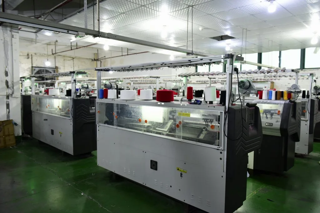 Flat-bed knitting machine producing jacquard knit panels